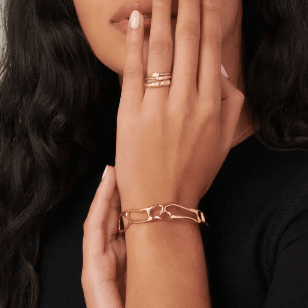 Close-up of a handcrafted bangle by Bario Neal, featuring open carved designs inspired by the Mississippi Alluvial Valley, made from reclaimed 14kt gold vermeil.